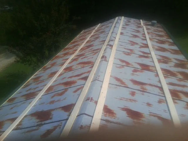 Rusted metal roof panels with new wood purlins before replacement — Storm Damage Roof Repair in Saylorsburg by Roofing Brothers