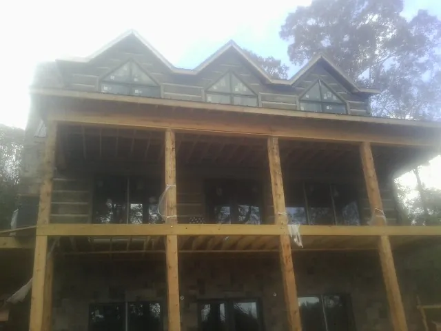 Dormers and porch framing on a large log home under construction — Roof Coating work by our crew in Saylorsburg