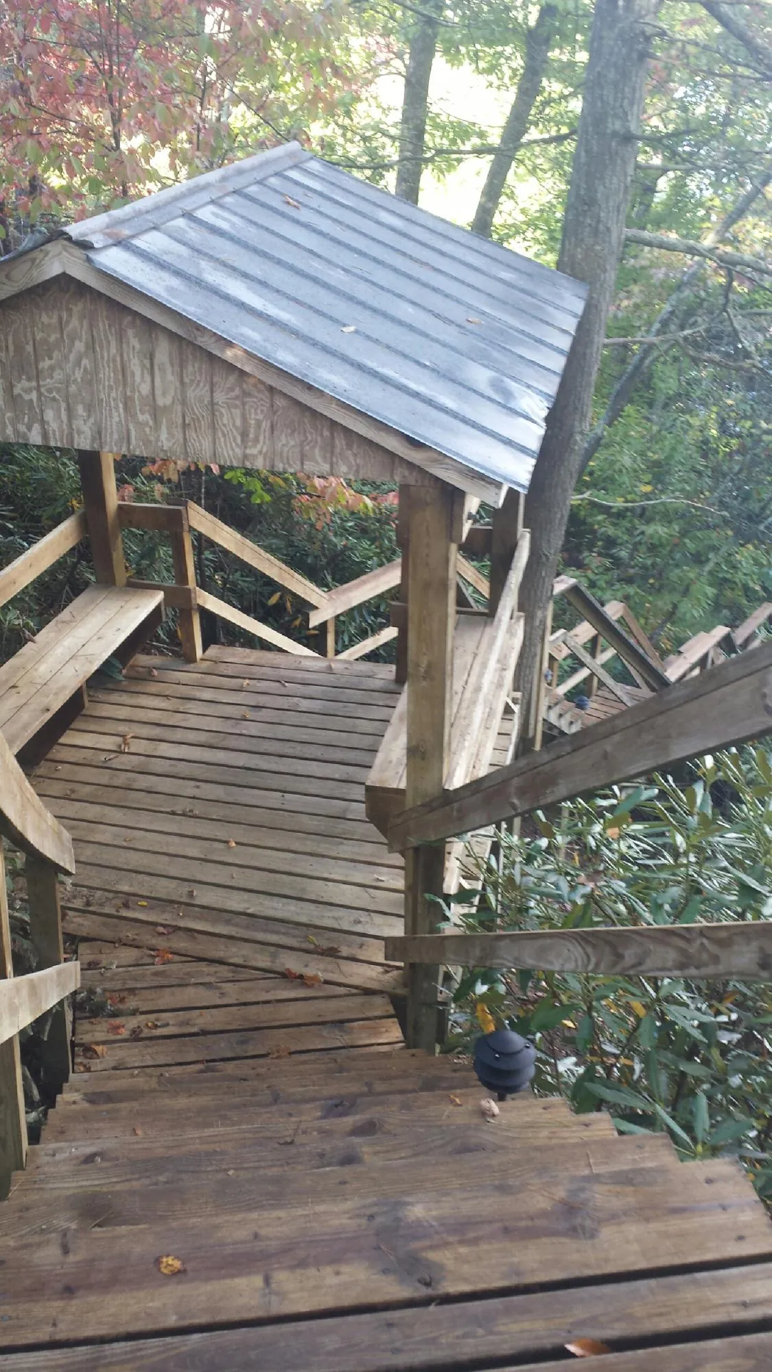 Metal roofed shelter over wooden steps on a wooded walkway — Skylight Repair & Installation work by our crew in Saylorsburg
