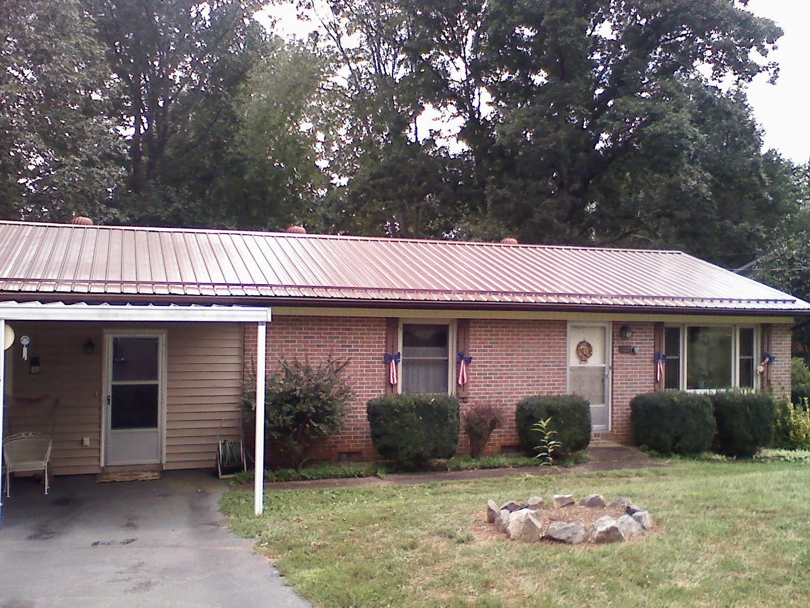 Bronze metal roof and carport on a brick ranch home — Roof Repair work by our crew in Saylorsburg